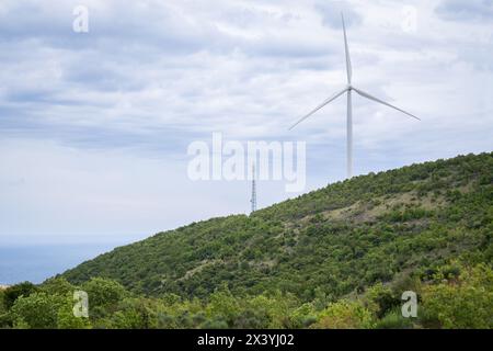 Éolienne sur le dessus du mountatin avec la mer en arrière-plan. Banque D'Images