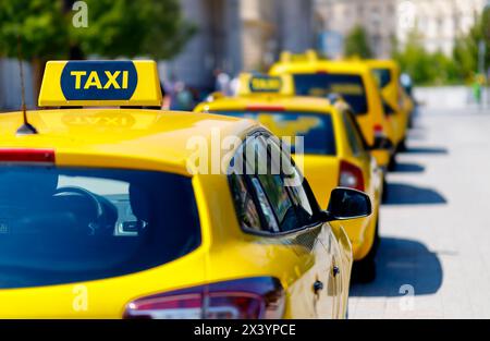 Les voitures de taxi jaunes sont alignées sur la rue avec un fond flou Banque D'Images