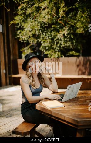 Sourire tatoué freelance travaillant à l'extérieur avec style Banque D'Images