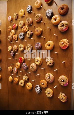 Beignets assortis affichés sur une planche de bois. Banque D'Images