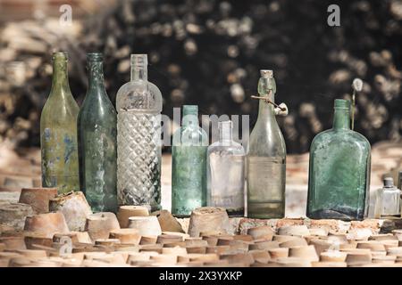 Bouteilles en verre antiques empilées à côté de pots en terre cuite Banque D'Images