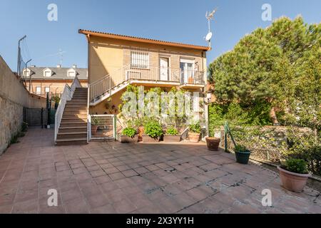 Façade d'un immeuble avec escaliers en terre cuite avec balustrades en métal blanc et de grands pots avec des plantes Banque D'Images