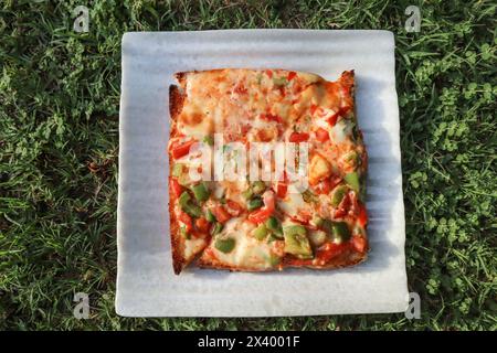 Savoureux et délicieux fromage végétal pain grillé ouvert recouvert de beaucoup de fromage et de poivron, de tomate et d'autres légumes Banque D'Images