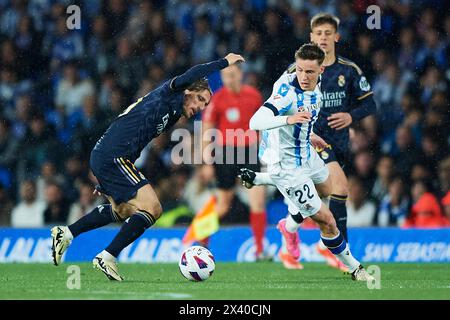 Luka Modric du Real Madrid CF concourent pour le ballon avec Benat Turrientes de la Real Sociedad lors du match LaLiga EA Sports entre la Real Sociedad et Banque D'Images