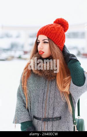 Jeune fille dans Un élégant vêtements chauds marchant un jour d'hiver sur le fond de la ville Banque D'Images