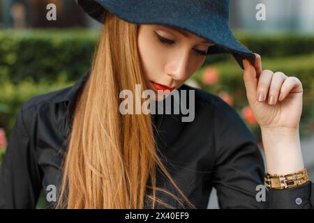 Jeune fille élégante dans Un chapeau noir, chemise, montres. Banque D'Images