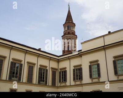 Section supérieure avec fenêtres et volets en bois de l'extérieur du Palais Royal et clocher de San Gottardo in Corte église à Milan ; Milan, Italie Banque D'Images