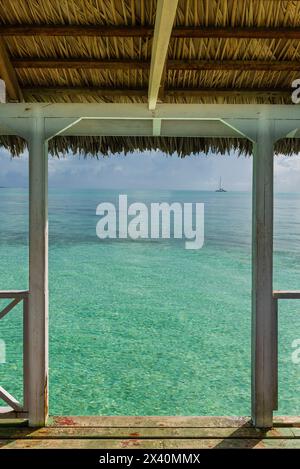Embarcadère d'un hôtel à Cayo Guillermo dans l'archipel des Jardines del Rey, avec une eau turquoise claire et un voilier au loin ; Cayo Guillermo, Cuba Banque D'Images