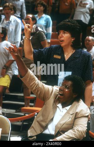 Austin Texas USA, 1988 : Barbara Jordan (devant), ancienne légiste de l'État et du Congrès, brandit le signe de la main « crochet 'em » lors d'un match de basket-ball féminin de l'Université du Texas. Donna Lopiano, directrice de l'athlétisme féminin de l'Université du Texas, soutient Jordan. ©Bob Daemmrich Banque D'Images