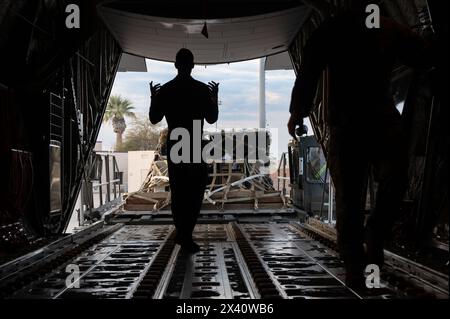 Les aviateurs de l'US Air Force affectés au 40th Air Lift Squadron et au 515th Air Mobility Element (AME) chargent de l'équipement sur un C-130J Super Hercules en soupo Banque D'Images