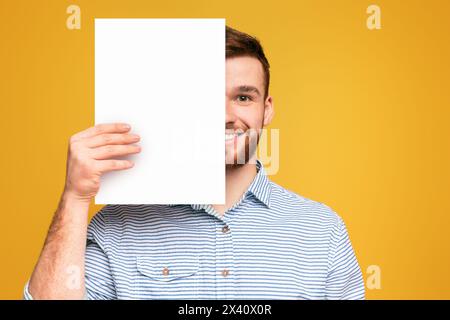 Homme tenant un morceau de papier blanc Banque D'Images