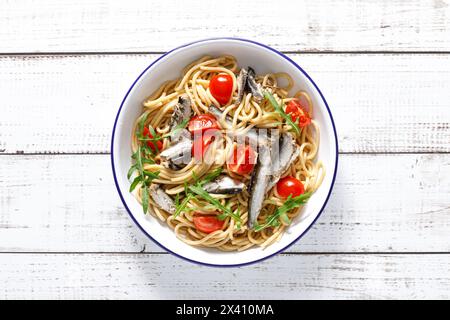 Pâtes à grains entiers avec sardines, tomate et roquette. Cuisine sicilienne italienne, vue de dessus Banque D'Images