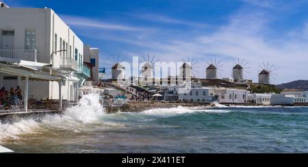 Surf éclaboussant le long du rivage et les moulins à vent emblématiques de Mykonos ; Mykonos, Grèce Banque D'Images