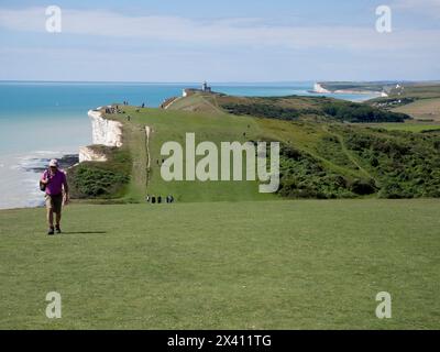Les touristes apprécient le sentier côtier de Beachy Head avec le phare de belle tout et la falaise de Seven Sisters en arrière-plan, Beachy Head, East Sussex, Royaume-Uni Banque D'Images