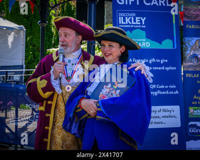 Des crieurs de ville debout côte à côte (Lady crier et 1er prix, livrée colorée des crieurs) - Ilkley, West Yorkshire, Angleterre Royaume-Uni. Banque D'Images