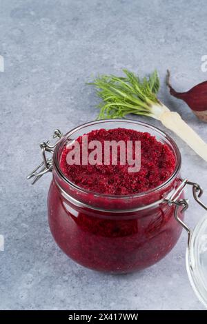 Sauce crémeuse au raifort de betterave en pot sur fond gris. Apéritif ou condiment pour viande et poisson. Nourriture végétalienne saine. espace pour le texte Banque D'Images