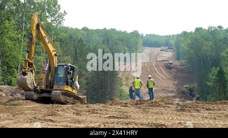 CASS CO, MN - 6 août 2021 : ouvriers et excavateurs sur le site de construction de l'oléoduc Enbridge Line 3 dans la forêt du Minnesota avec bulldozer dans le distan Banque D'Images