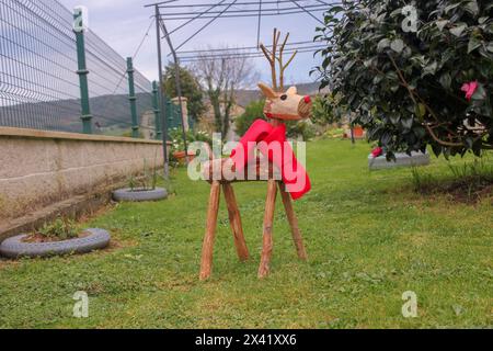 un cerf fait de bois est dans le jardin Banque D'Images