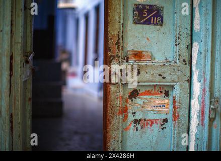 Porte à moitié ouverte fortement marquée vers une habitation à Varanasi, Inde. Banque D'Images