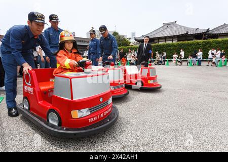 Tokyo, Japon. 29 avril 2024. Les pompiers aident les enfants à monter dans des camions de pompiers pendant les matsuri commémoratifs des pompiers d'Edo au temple Yutenjoi. Les pompiers de Tokyo et les membres du groupe de préservation culturelle des pompiers d'Edo organisent des expositions en l'honneur des pompiers morts pendant les périodes Edo et Showa. (Photo Damon Coulter/SOPA images/SIPA USA) crédit : Sipa USA/Alamy Live News Banque D'Images