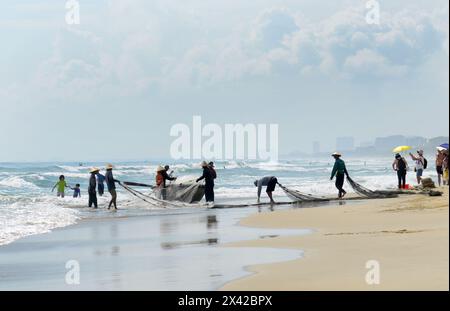 Pêcheurs vietnamiens tirant un grand filet de pêche de la plage de Da Nang, Vietnam. Banque D'Images