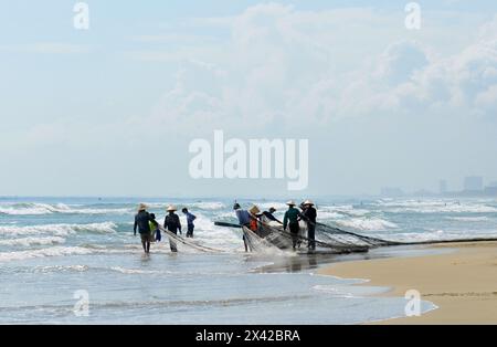 Pêcheurs vietnamiens tirant un grand filet de pêche de la plage de Da Nang, Vietnam. Banque D'Images