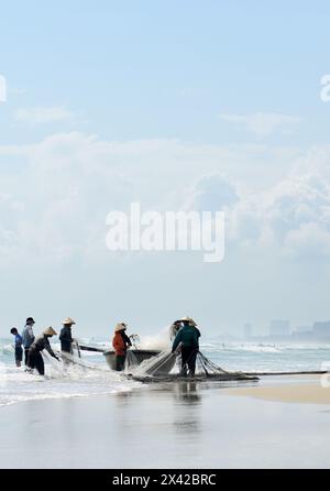 Pêcheurs vietnamiens tirant un grand filet de pêche de la plage de Da Nang, Vietnam. Banque D'Images