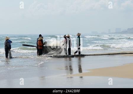 Pêcheurs vietnamiens tirant un grand filet de pêche de la plage de Da Nang, Vietnam. Banque D'Images