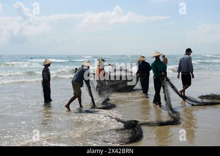 Pêcheurs vietnamiens tirant un grand filet de pêche de la plage de Da Nang, Vietnam. Banque D'Images