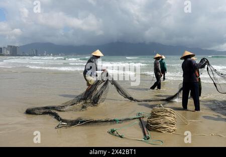 Pêcheurs vietnamiens tirant un grand filet de pêche de la plage de Da Nang, Vietnam. Banque D'Images