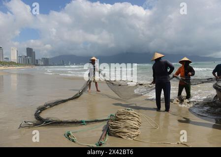 Pêcheurs vietnamiens tirant un grand filet de pêche de la plage de Da Nang, Vietnam. Banque D'Images