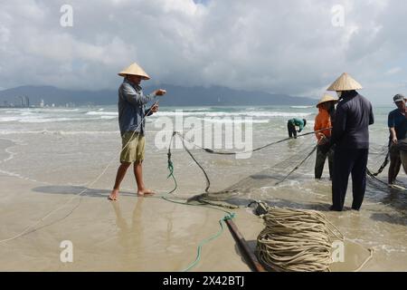 Pêcheurs vietnamiens tirant un grand filet de pêche de la plage de Da Nang, Vietnam. Banque D'Images