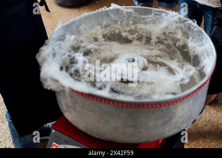 Barbe à papa, fil de bonbon et fil de fée ont survolé lors d'un événement social pour les enfants. il est fabriqué à partir de sucre à la machine. Banque D'Images