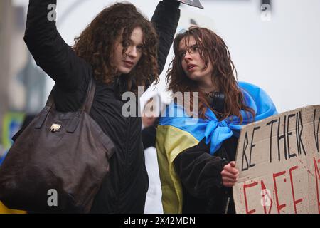 Jeunes filles ukrainiennes en manifestation sous la pluie. Des militants manifestent pour la libération des défenseurs capturés de Marioupol. Kiev - 21 avril 2024 Banque D'Images