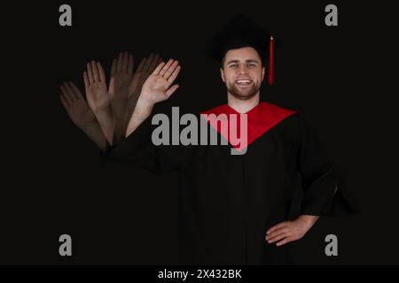 Photo stroboscopique d'un diplômé masculin agitant la main sur fond sombre Banque D'Images