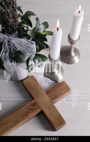 Bougies allumées, bouquet avec branches de saule et croix sur table en bois blanc, vue au-dessus Banque D'Images