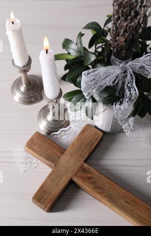 Bougies allumées, bouquet avec branches de saule et croix sur table en bois blanc, vue au-dessus Banque D'Images