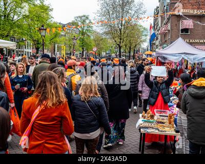 27 avril, Amsterdam. Le jour du roi est réputé pour être l'une des festivités les plus grandes et les plus colorées du pays, en particulier à Amsterdam. La ville regorge d'orange tandis que les gens apprécient la plus grande fête de rue de l'année, en profitant des marchés gratuits et en s'amusant sur les bateaux le long des canaux. Banque D'Images