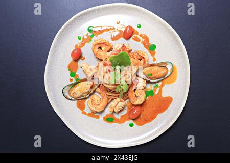 Spaghettis épicés sautés avec fruits de mer mélangés et herbes sur plaque blanche, style thaïlandais Banque D'Images