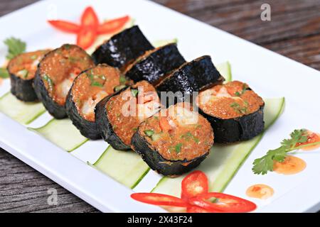 Gâteaux de poisson frits farcis de crevettes fraîches à l'intérieur enveloppés dans des feuilles d'algues avant la friture Banque D'Images