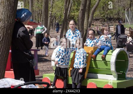 Une famille juive hassidique avec des enfants portant des hauts identiques, pose pour une photo pendant la Pâque. Dans une ferme du comté de Rockland. Banque D'Images