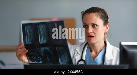 Excitée femme médecin tenir x-ray film dans la main contre Banque D'Images