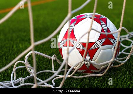 Gros plan du ballon de football à l'intérieur du terrain net. Ballon de football à l'intérieur du champ de but. Concept de fièvre du football Banque D'Images