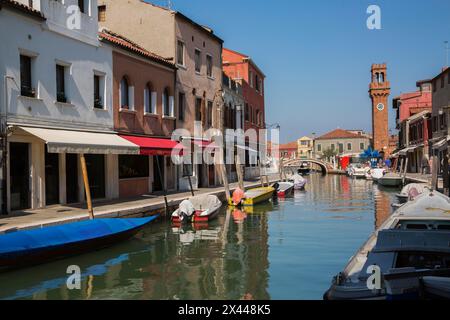 Bateaux amarrés sur le canal avec des bâtiments résidentiels colorés, maisons, magasins et tour de l'horloge sur la place San Stefano, île de Murano, lagune de Venise Banque D'Images