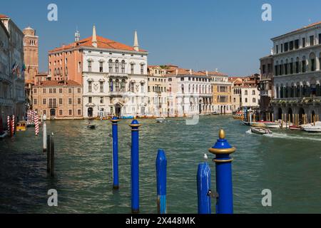 Postes d'amarrage bleus et bateaux-taxis sur le Grand canal avec bâtiments résidentiels de style Renaissance, quartier San Polo, Venise Banque D'Images