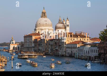 Bateaux-taxis et vaporettos sur le Grand canal avec des bâtiments de palais de style Renaissance et la basilique Santa Maria della Salute à Dorsoduro Banque D'Images