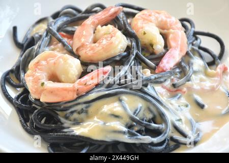 spaghetti à l'encre de calmar noir avec vinaigrette aux crevettes sauce crème carbonara blanche sur l'assiette Banque D'Images