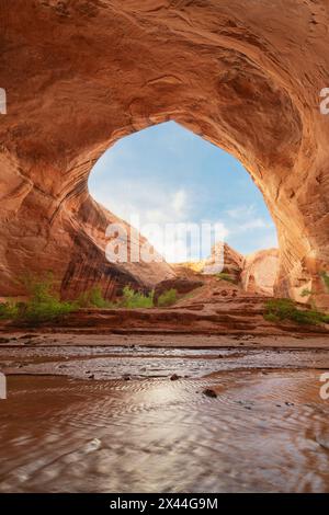 De la vapeur s'écoule dans une alcôve géante adjacente à Jacob Hamblin Arch à Coyote Gulch, dans la zone de loisirs nationale de Glen Canyon, Utah. Banque D'Images