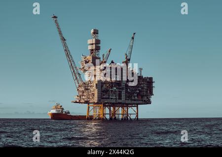 Vue panoramique rapprochée de la plate-forme de jackup pétrolière et gazière offshore, pendant les opérations de fret avec navire de ravitaillement, pendant une belle journée en mer. Banque D'Images