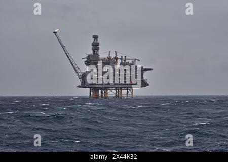 Vue de la plate-forme offshore de jackup à l'horizon sur une journée nuageuse grise dans la mer avec des vagues. Banque D'Images